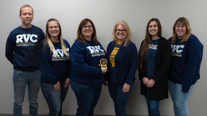 six diverse individuals stand side-by-side with the award