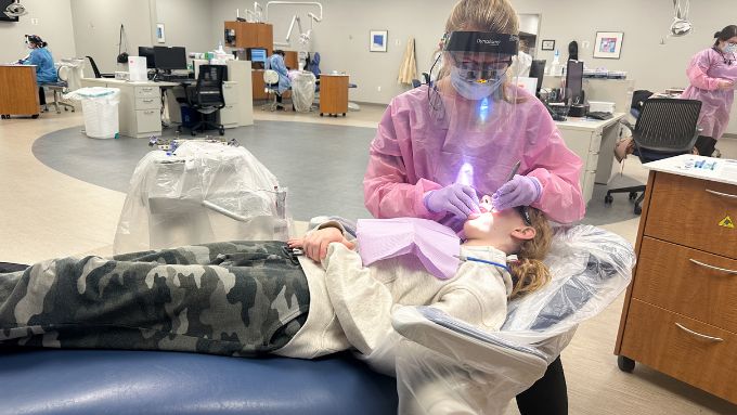 Dental Hygiene student performing a dental exam