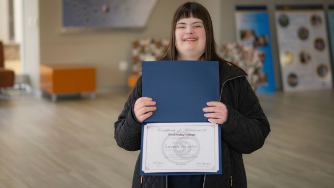 Young woman with Down's Syndrome holding a certificate