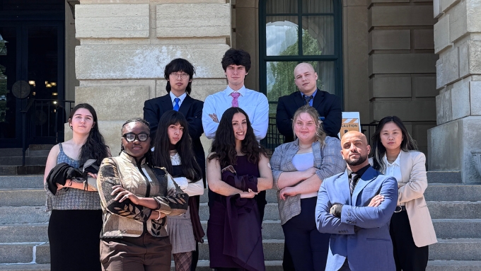 a diverse group of students stand on the steps of the Illinois Capitol building