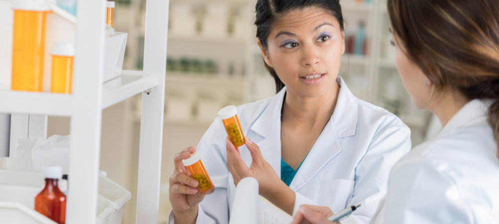 female wearing white coat holding prescription bottle