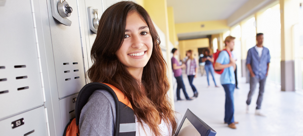 close up of high school student at locker holding books