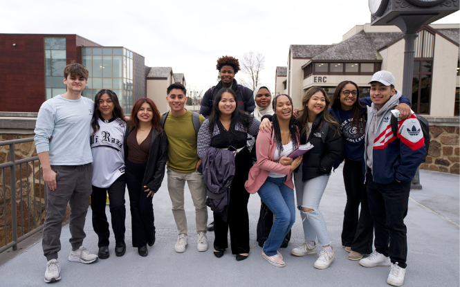 group of students huddled together on main campus bridge