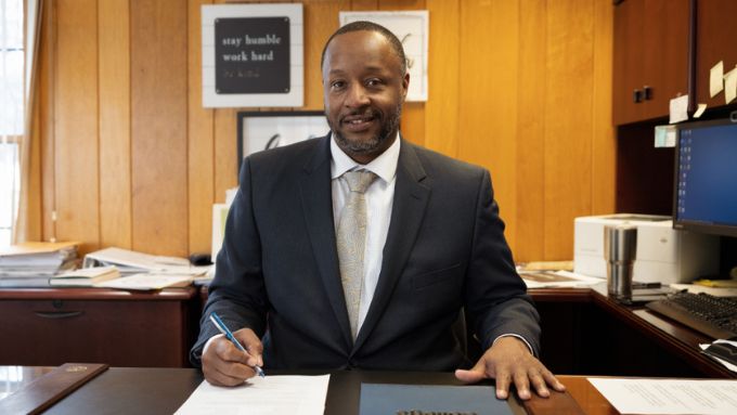 RVC President Dr. Spearman sits at his desk with a pen in hand