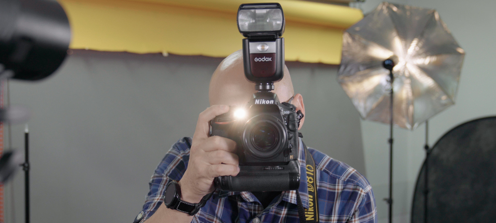 student holding camera in front of face