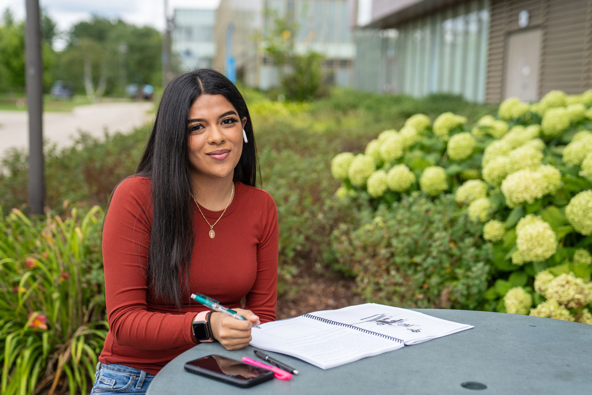 student sitting at table while studying outside